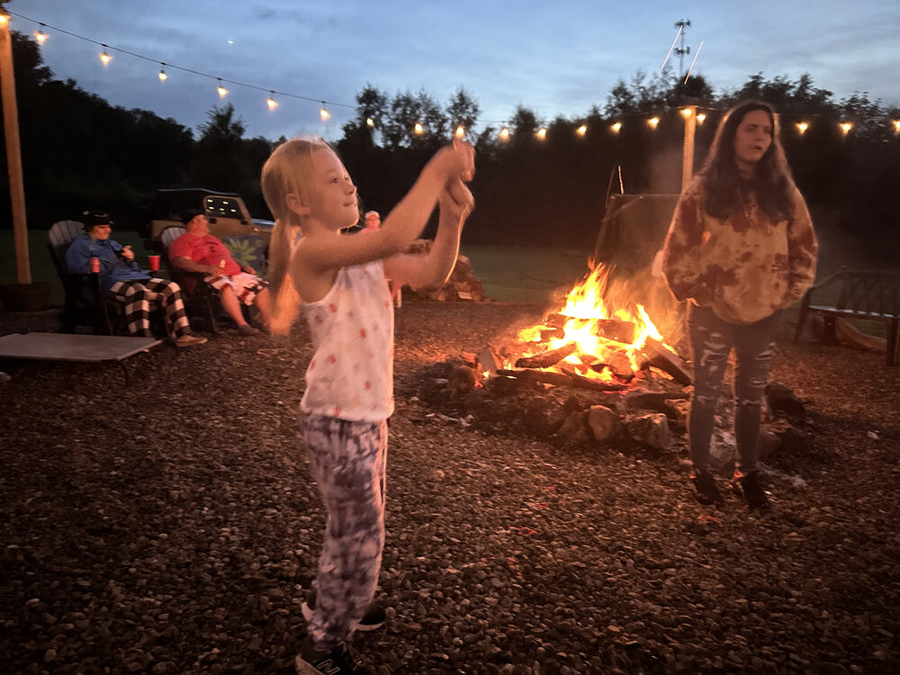 Family gathered around the bonfire at dusk