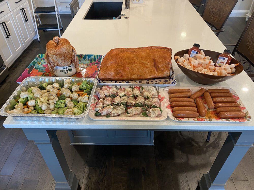 A loaded buffet table of salads, sides, and grilled meats