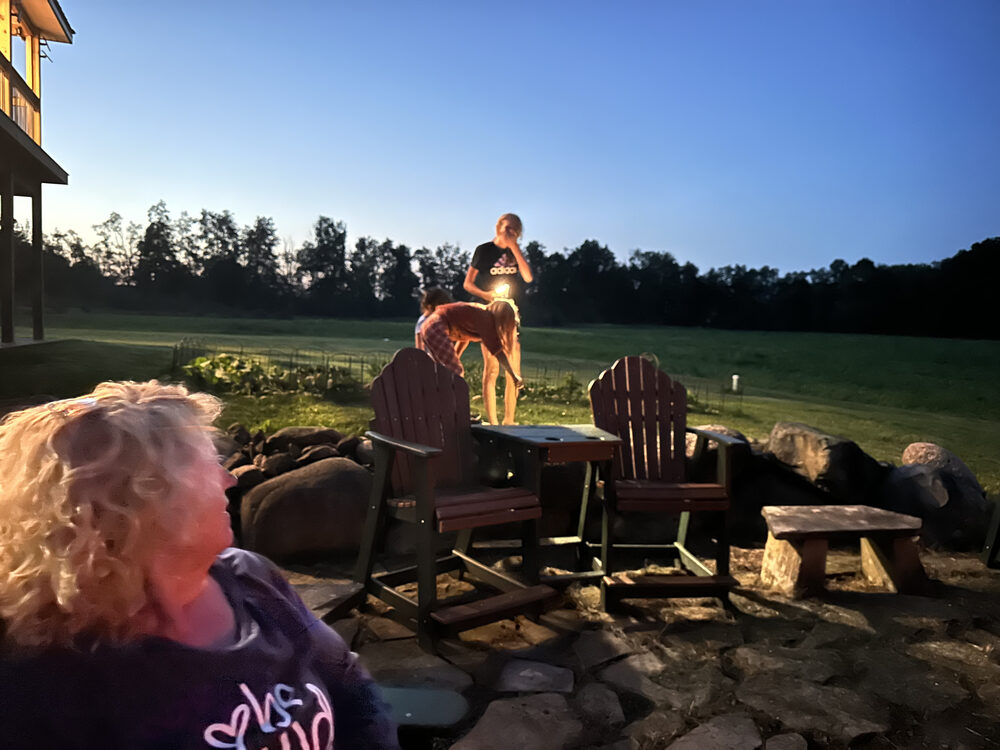 The Tompkins family gathered around the fire pit at dusk