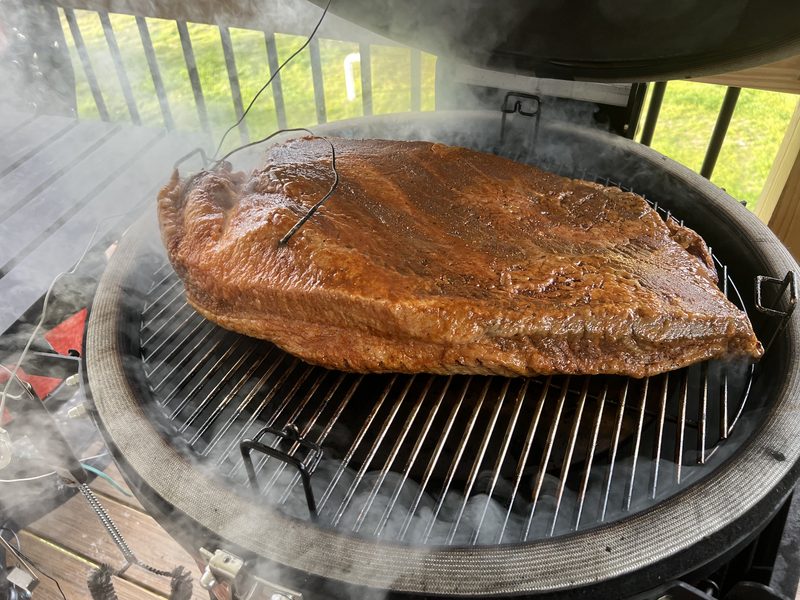 A whole brisket smoking on the grill