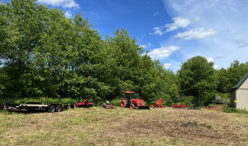 Tractors and equipment in a clearing at Tompkins Farm